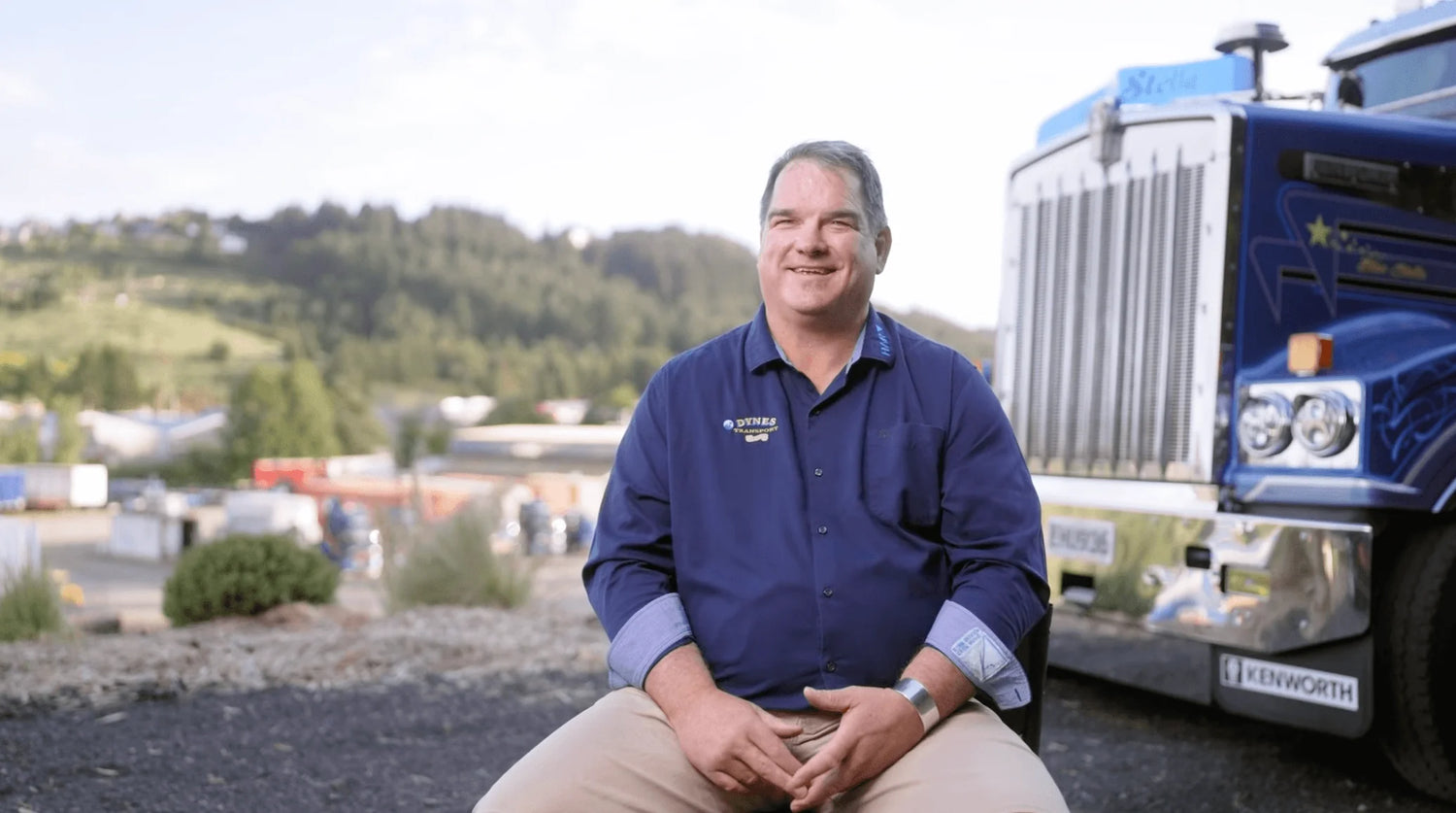 Dynes Transport: 50 Years of Hard Work, Loyalty and Kenworth - smiling man in front of a Kenworth truck.