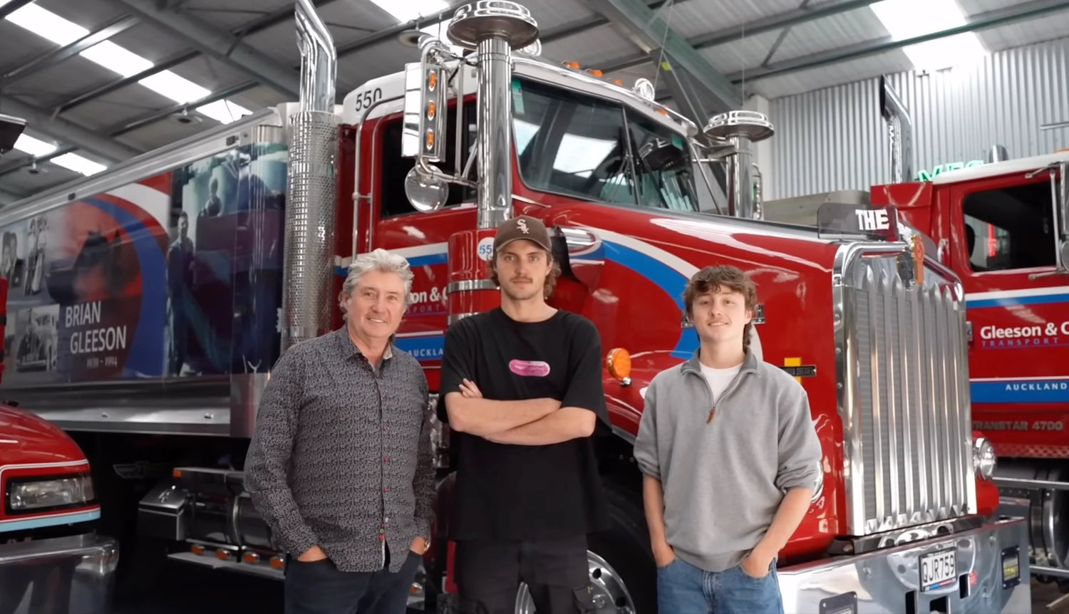 Gleeson & Cox: Over a Century of Moving Auckland Forward with family members by a truck.