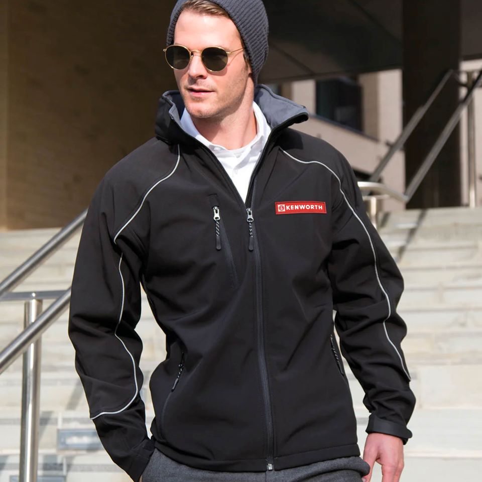 Man wearing Kenworth outerwear jackets and vests, stylish black jacket with zippers and logo.