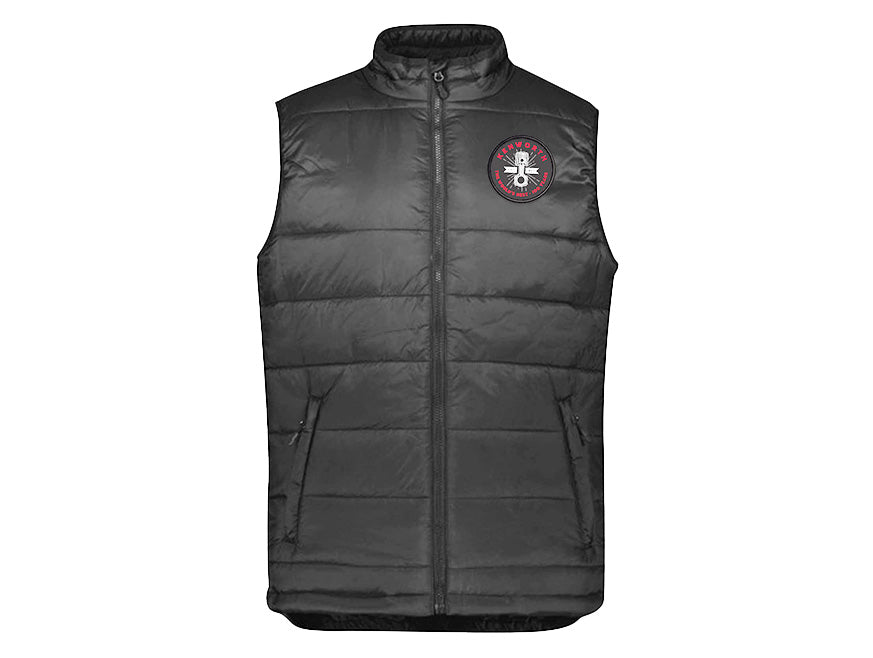 The VEST KW MENS WORLDS is a black, sleeveless alpine vest featuring a front zipper, two zippered pockets, and a circular red, white, and black logo with crest detail on the left chest—ideal for outdoor layering.