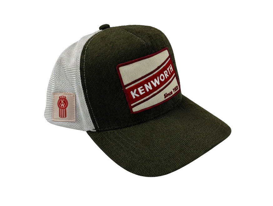 The Retro Kenworth Corduroy Cap is green and white with a breathable mesh back, featuring a red and white patch reading KENWORTH Since 1923 on the front and a small Kenworth logo patch on the side.