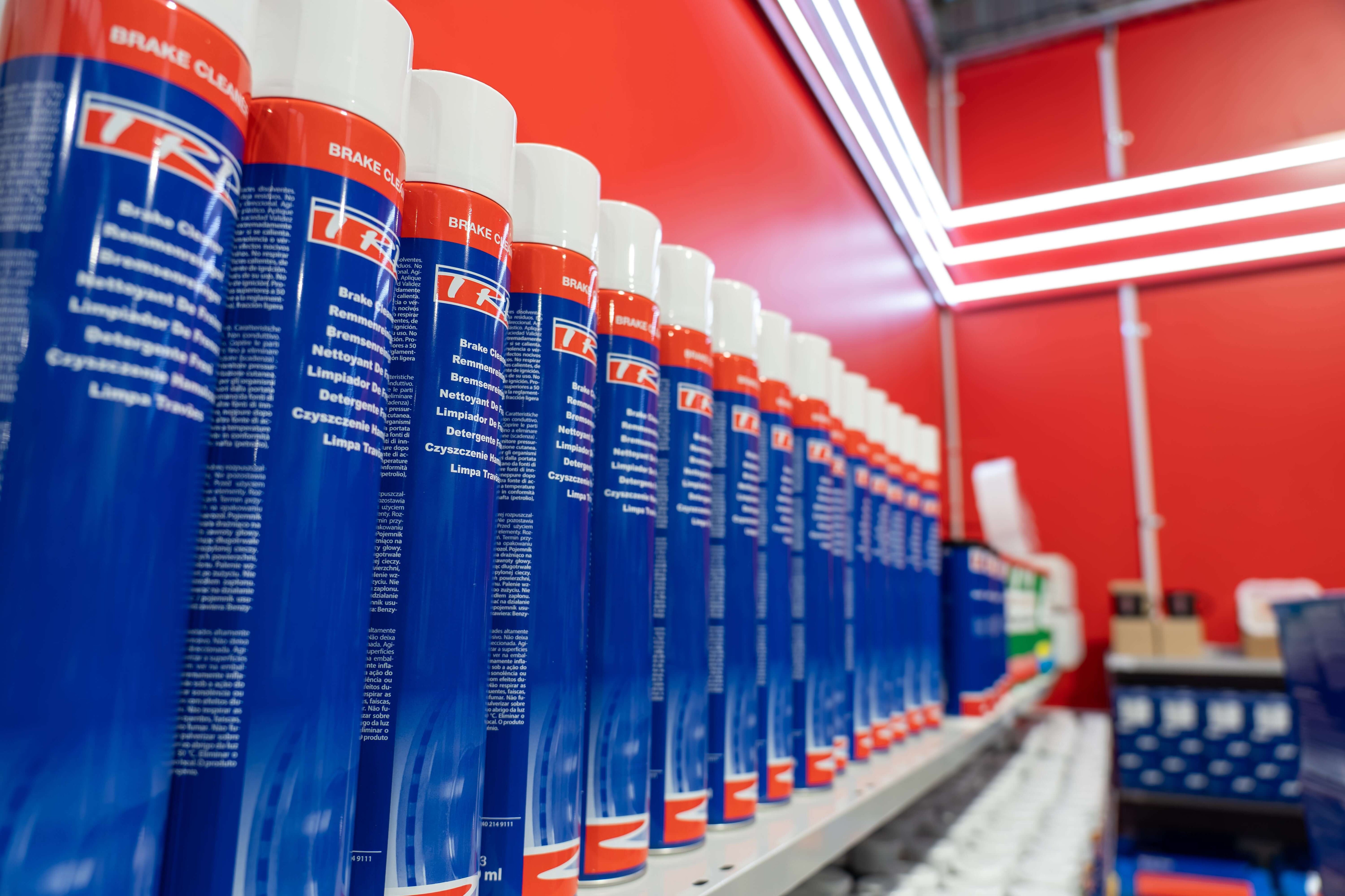 Shelves lined with blue aerosol cans of brake cleaner, showcasing clear product labeling and vibrant colors.