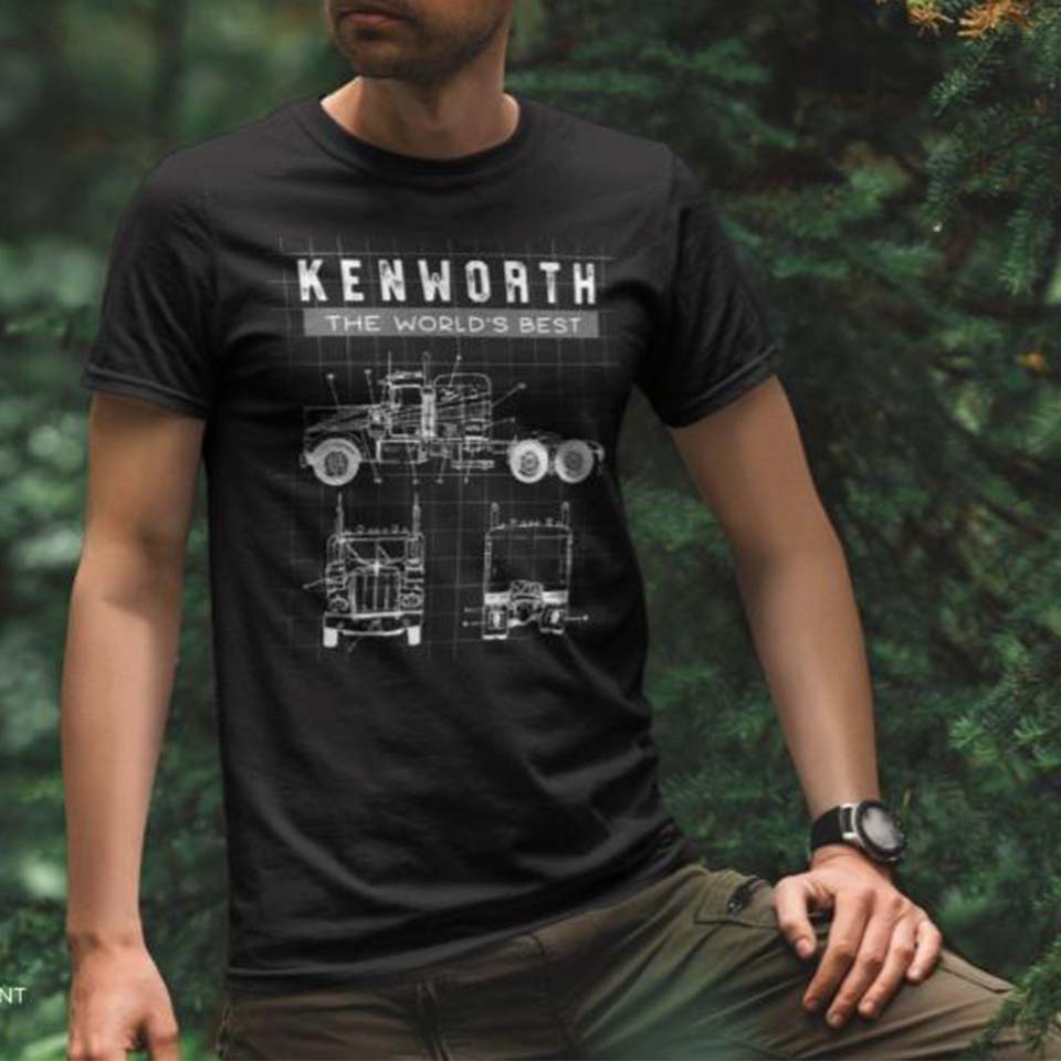 A person in an outdoor setting wears a black T-shirt featuring white blueprint-style drawings of a Kenworth truck and the text “KENWORTH THE WORLDS BEST” at the top.
