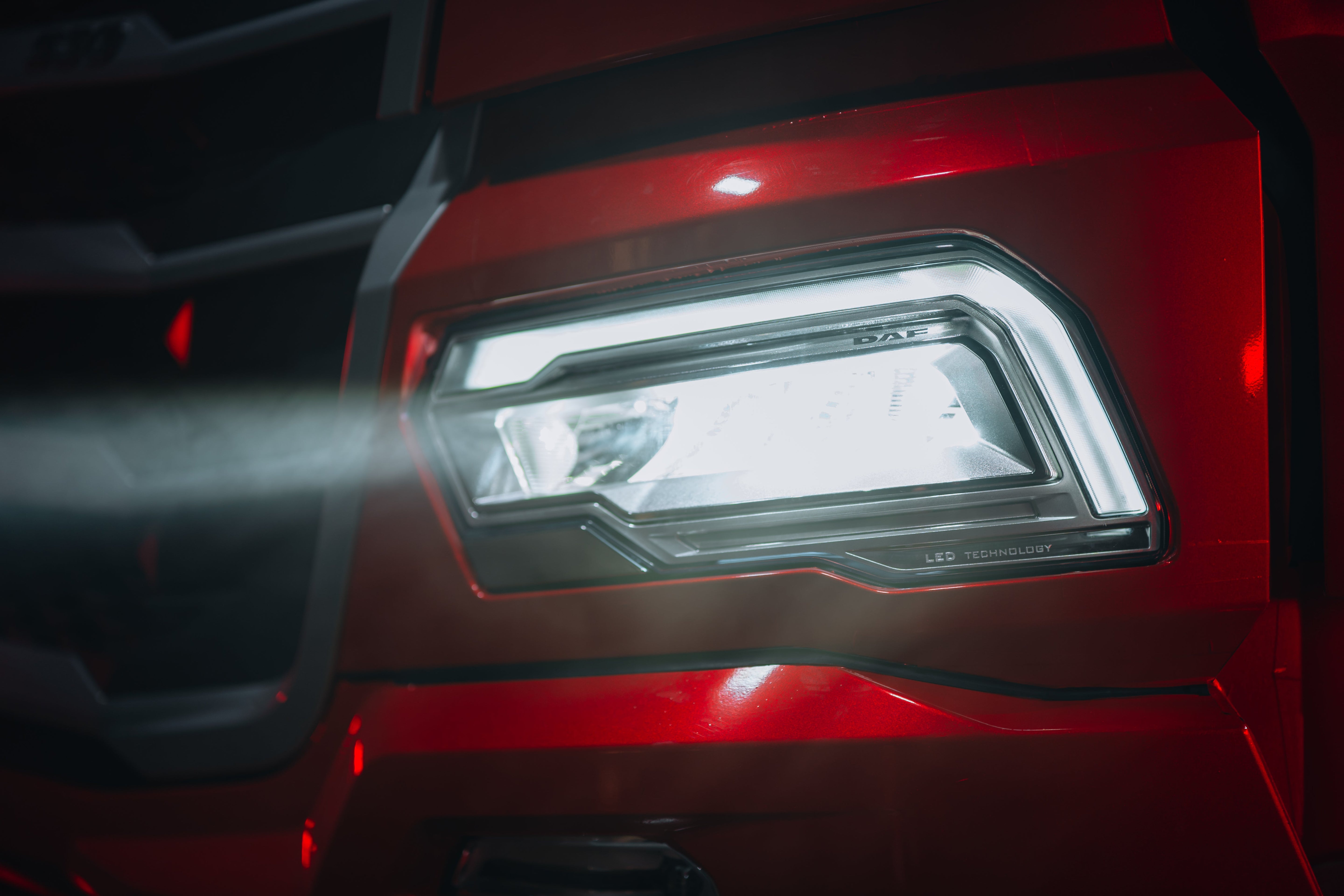 Close-up of a red truck's LED driving light, showcasing LED truck lighting solutions for enhanced visibility.