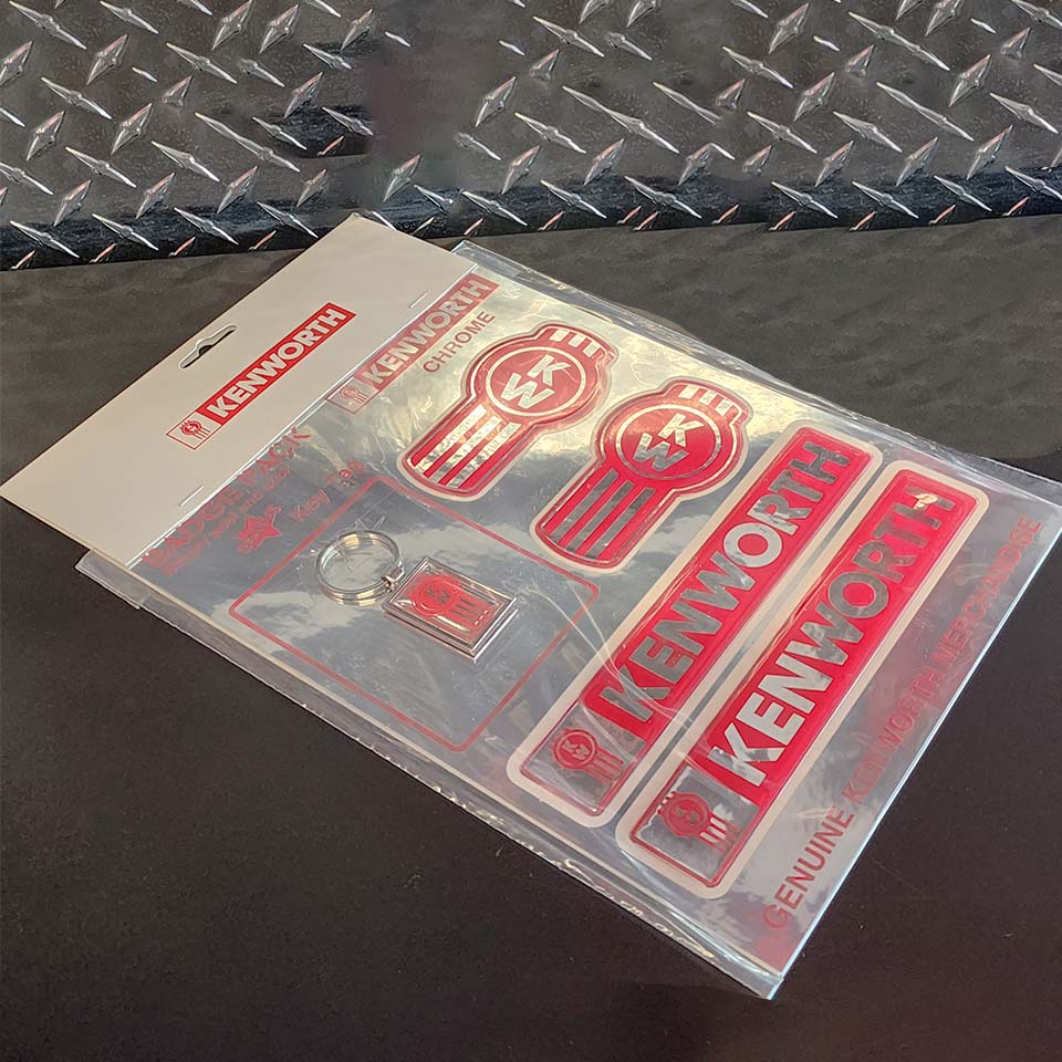 The DECAL KW SET CHROME LEGACY includes red and white Kenworth stickers, a chrome Legacy decal, and a keychain, all displayed on a black surface with a metallic diamond-plate background.