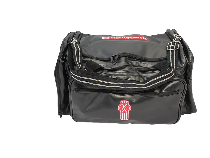 The BAG KW PREMIUM is a black 50L Kenworth travel bag featuring a front zipper pocket, striped shoulder strap, and red and white Kenworth logo on both the pocket and top flap, shown against a white background.