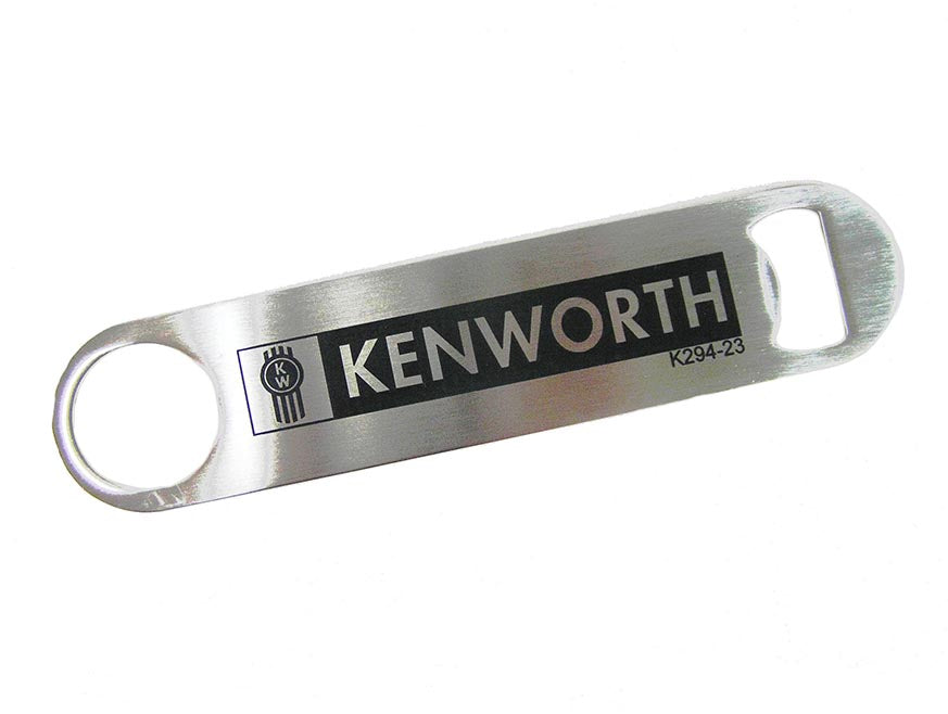 The BOTTLE OPENER KW is a metal Kenworth bottle opener with "KENWORTH" and the logo printed on it. It has a circular hole on one end and a bottle-opening slot on the other—a great Kenworth gift for fans or collectors.