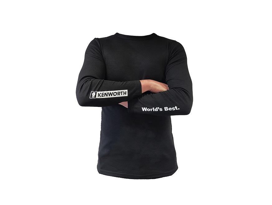 Wearing the SHIRT KW THERMAL, featuring "KENWORTH" on the right sleeve and "World’s Best." on the left, a person stands with arms crossed against a white background.