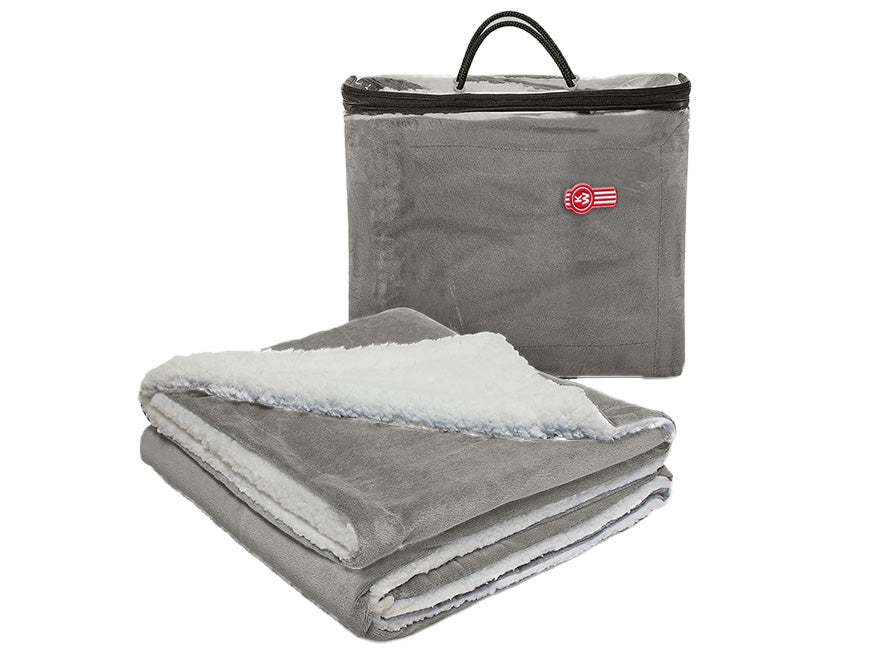 The BLANKET KW GREY/WHIT FLEECE, a gray fleece blanket with a white sherpa lining, is shown in front of a matching reusable carry bag with zipper, handle, and red and white logo.