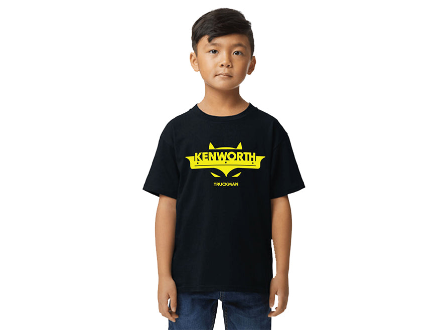 A young boy with short dark hair and a neutral expression wears the TEE SHIRT KW KIDS TRUCKMAN, featuring a black color with a yellow Kenworth Truckman logo and stylized eyes design on the front.