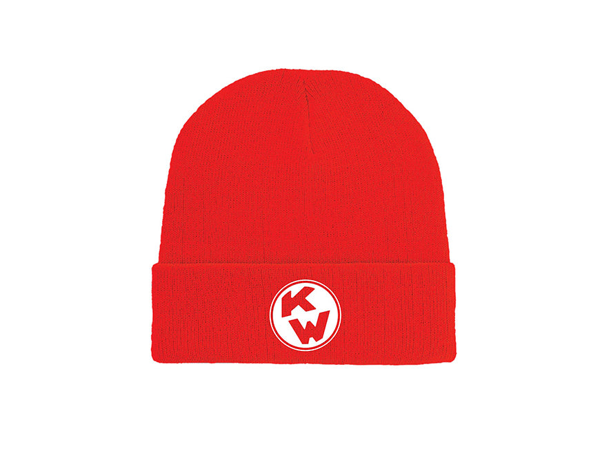 The BEANIE KW VINTAGE RED is a vibrant red knit hat with a folded brim and a circular white patch displaying bold red KW letters on the front. Ideal for workplace warmth or accessorizing with your favorite Kenworth banner. Plain white background.