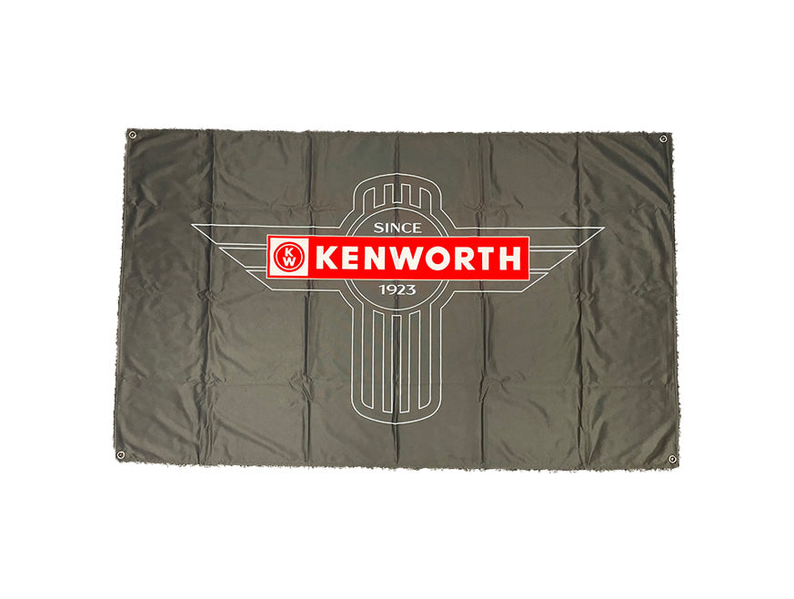A black Kenworth T-bar cab flag features the iconic Kenworth logo with "SINCE 1923" in white on red, centered over a stylized winged emblem—perfect for any trucking enthusiast.