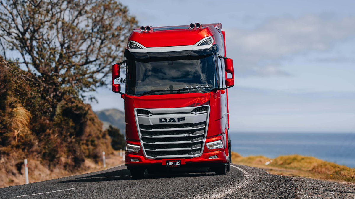 Red New Generation DAF XG+ approaching on a rural road