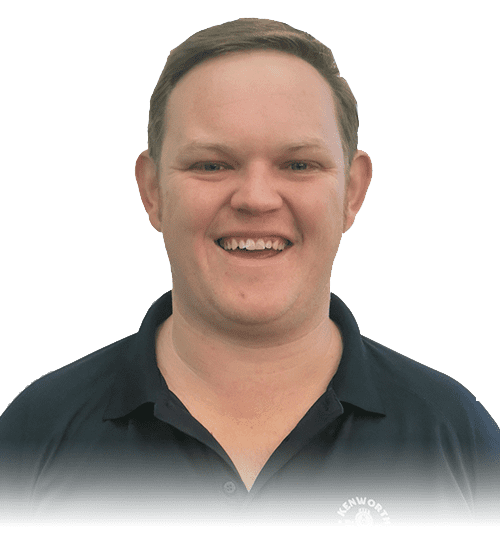 A smiling person with short brown hair wearing a dark collared shirt, shown against a white background with the lower part of the image faded out.