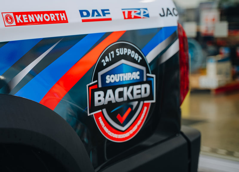 The side of a vehicle displays a colorful decal reading 24/7 Support Southpac Backed with branding logos for Kenworth, DAF, and TRP above it.