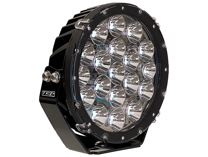 The LAMP DRIVING LIGHT LED 9 is a large round driving lamp with 19 reflectors, a hybrid beam pattern, black metal housing, visible mounting bolts, and a TRP logo on the side for enhanced visibility.