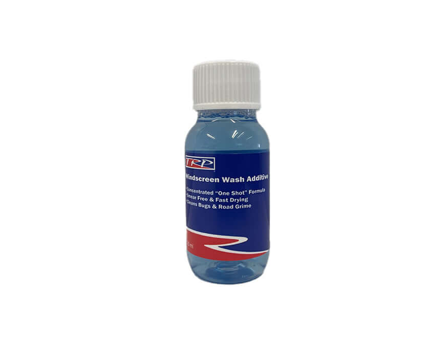 A small clear plastic bottle with a white cap contains 50ml of blue liquid. The label reads WINDSCREEN WASH 50ML on a blue and red background. Features a concentrated formula for streak-free cleaning.